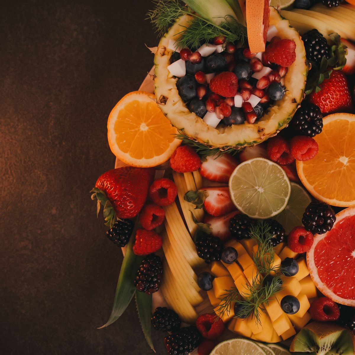 Fruta fresca variada sobre fondo oscuro: nutrición personalizada